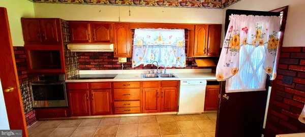 a kitchen with stainless steel appliances wooden cabinets and a stove top oven