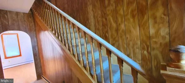 a view of staircase with railing and white walls