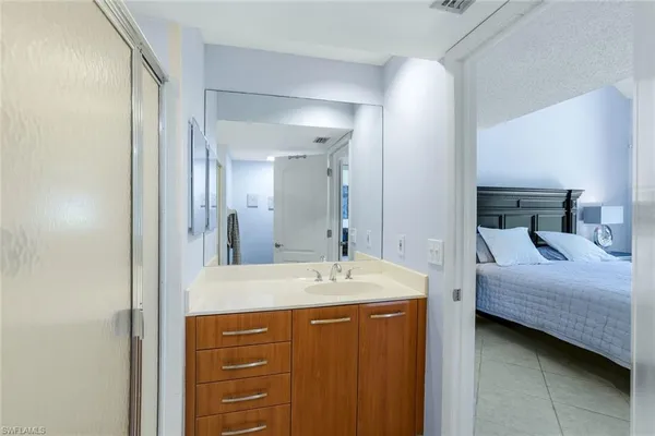 a bedroom with a bed and a table in it with window