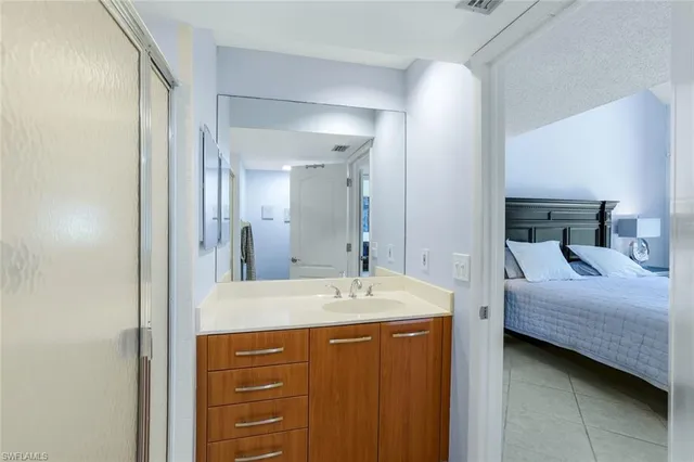 a bedroom with a bed and a table in it with window