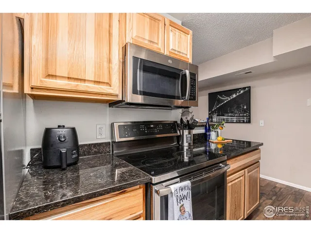 a kitchen with stainless steel appliances granite countertop a sink stove and microwave