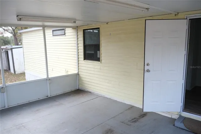 an empty room with windows and fireplace