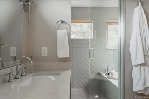 a bathroom with a granite countertop sink a toilet and a mirror