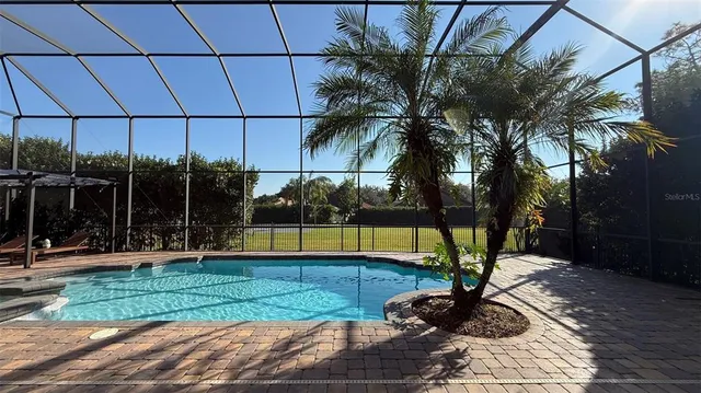 a view of a backyard with swimming pool and sitting area
