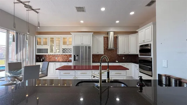 a kitchen with stainless steel appliances kitchen island granite countertop a stove and a sink