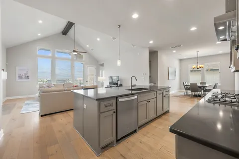 a kitchen with stainless steel appliances granite countertop a sink refrigerator and cabinets