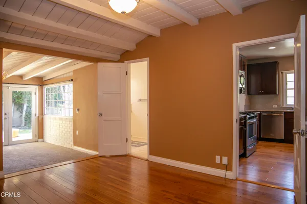 a view of a hallway with wooden floor and a kitchen