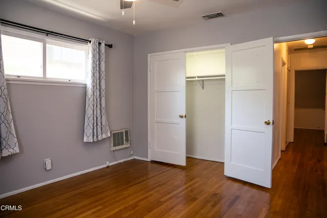 an empty room with wooden floor and a window