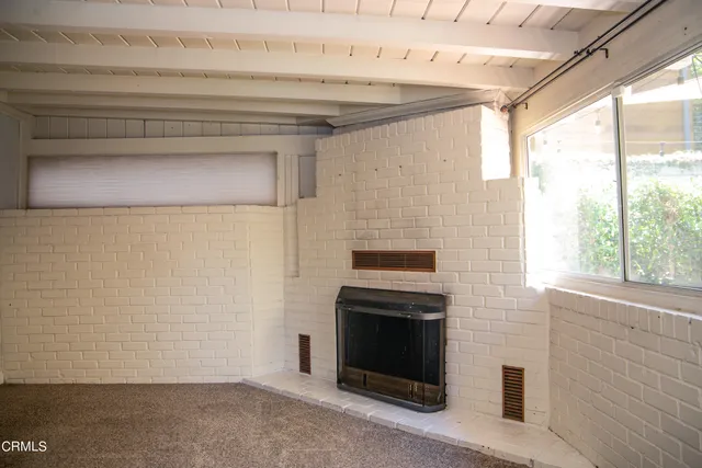 a view of empty room with a fireplace and a window