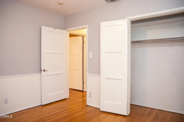 a view of empty room with wooden floor