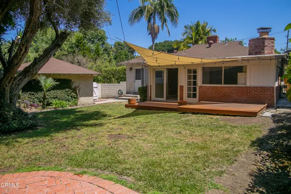 a view of a house with a yard and potted plants