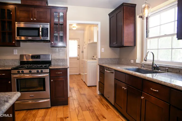 a kitchen with stainless steel appliances a stove a sink and a microwave