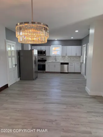 a view of kitchen with stainless steel appliances granite countertop a stove and refrigerator