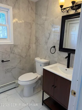 a bathroom with a toilet sink and mirror