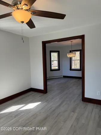 an empty room with wooden floor and windows