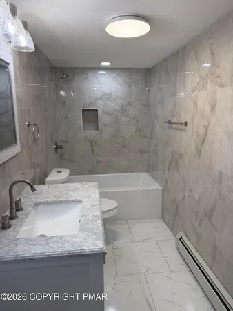a bathroom with a granite countertop sink a toilet and bathtub
