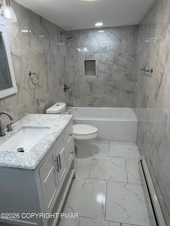 a bathroom with a granite countertop sink a toilet and bathtub