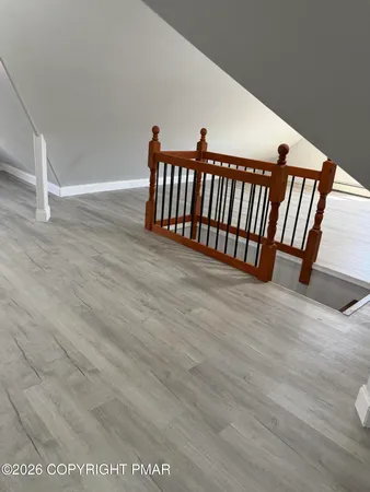 a view of an empty room with wooden floor