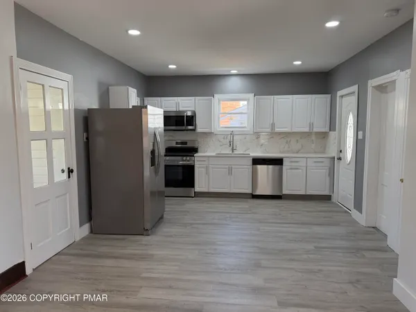 a kitchen with stainless steel appliances granite countertop a refrigerator and a stove top oven