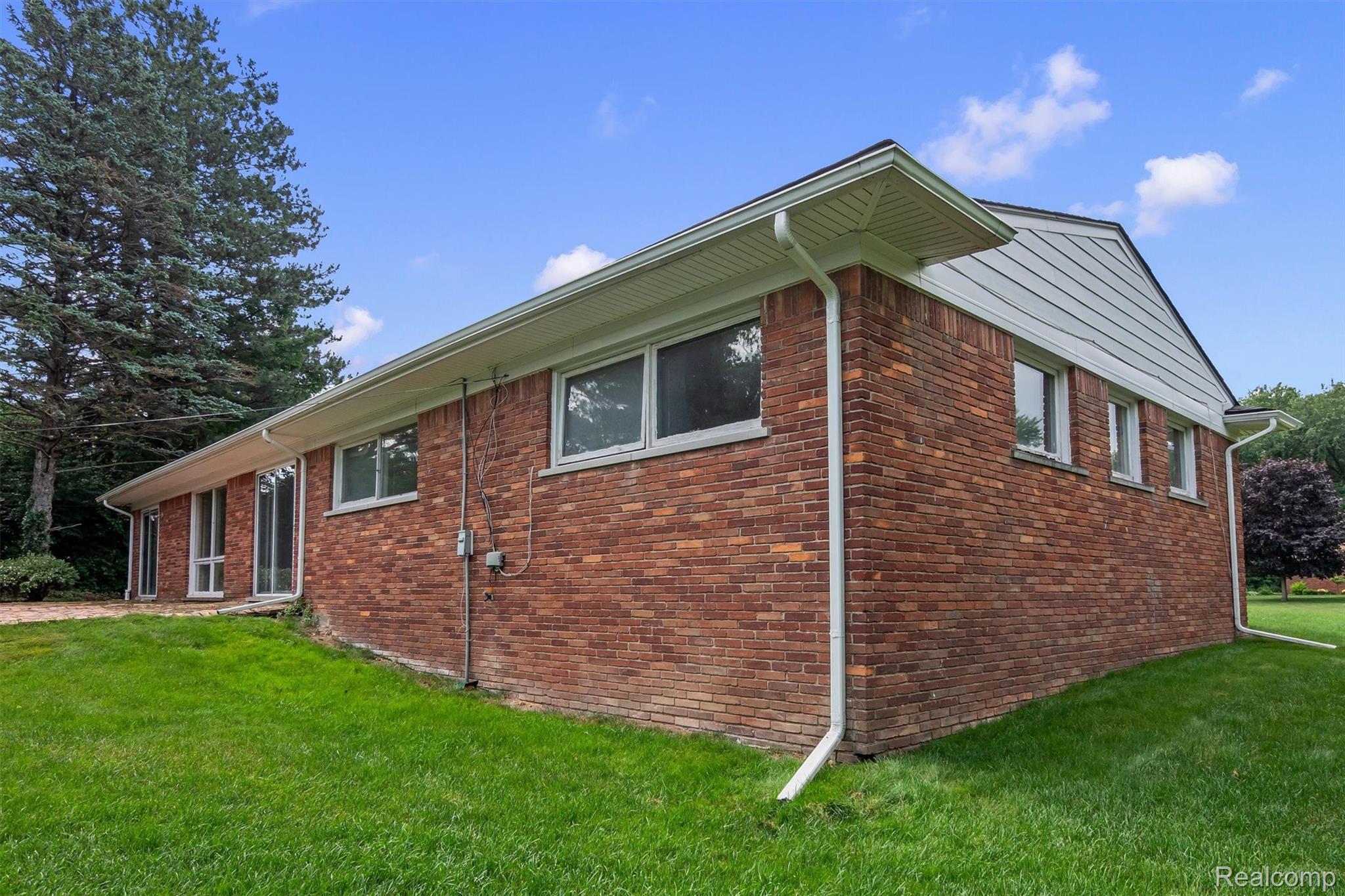 1151 Peveril Road Bloomfield Hills, MI 48304 - Photo 38 of 39 Brick exterior featuring white trim and multiple windows