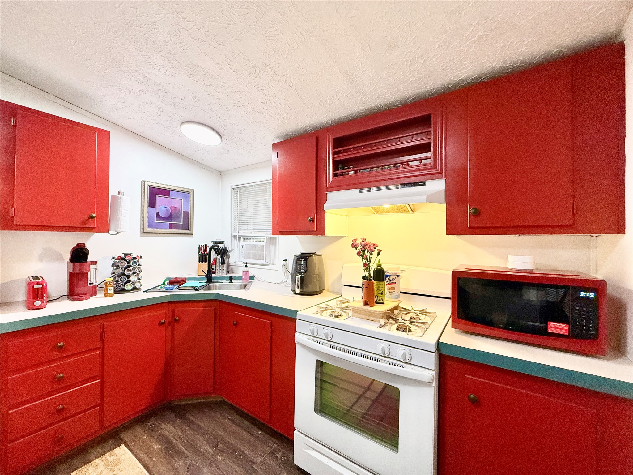 2015 Holly Street Austin, TX 78702 - Photo 6 of 24 Bold red cabinetry creates a striking, energetic kitchen atmosphere.