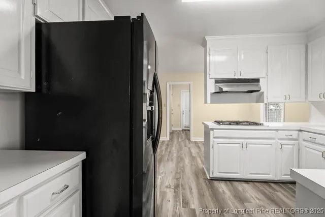 a kitchen with a refrigerator and a stove top oven