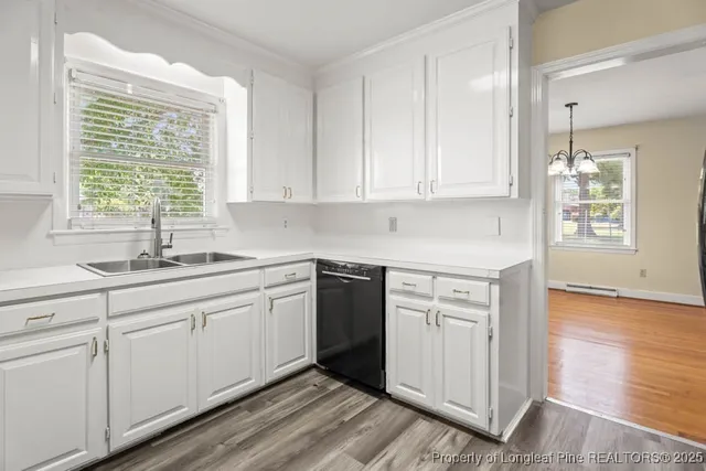 a kitchen with granite countertop white cabinets and a sink