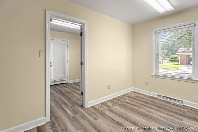 a view of a room with wooden floor and window