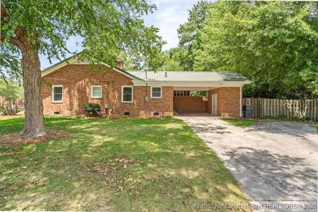 a view of a patio with table and chairs and wooden fence