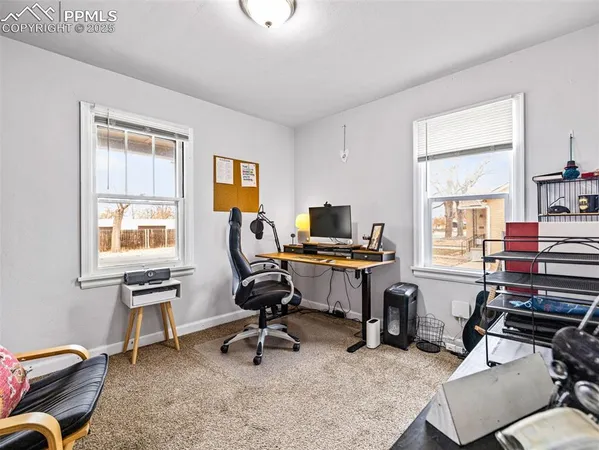 a view of a workspace with furniture and a window