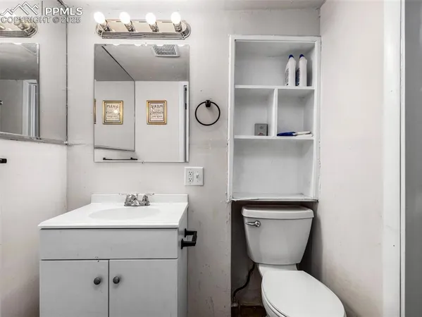 a bathroom with a toilet sink and mirror