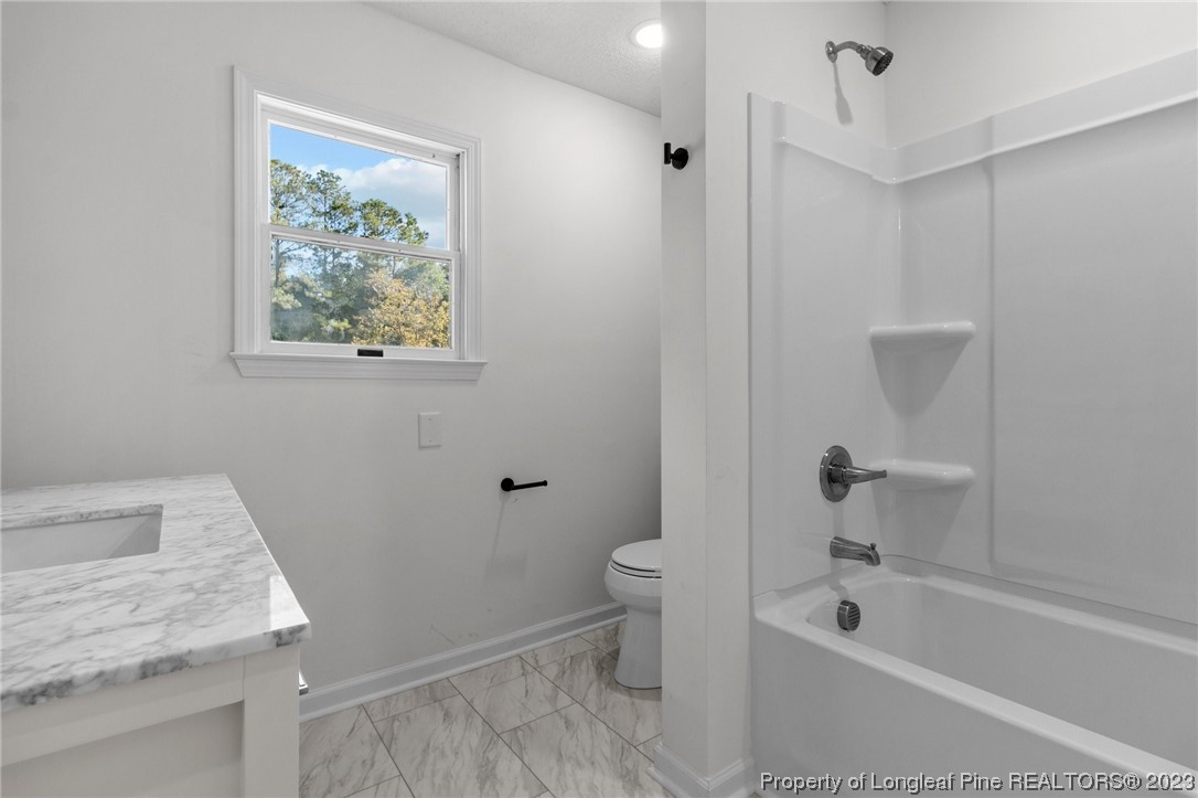 4659 Tabor Church Road Fayetteville, NC 28312 - Photo 20 of 50 a bathroom with a granite countertop sink a toilet and bathtub