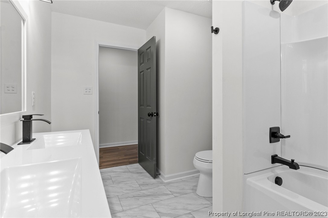 4659 Tabor Church Road Fayetteville, NC 28312 - Photo 22 of 50 a bathroom with a sink a toilet and shower