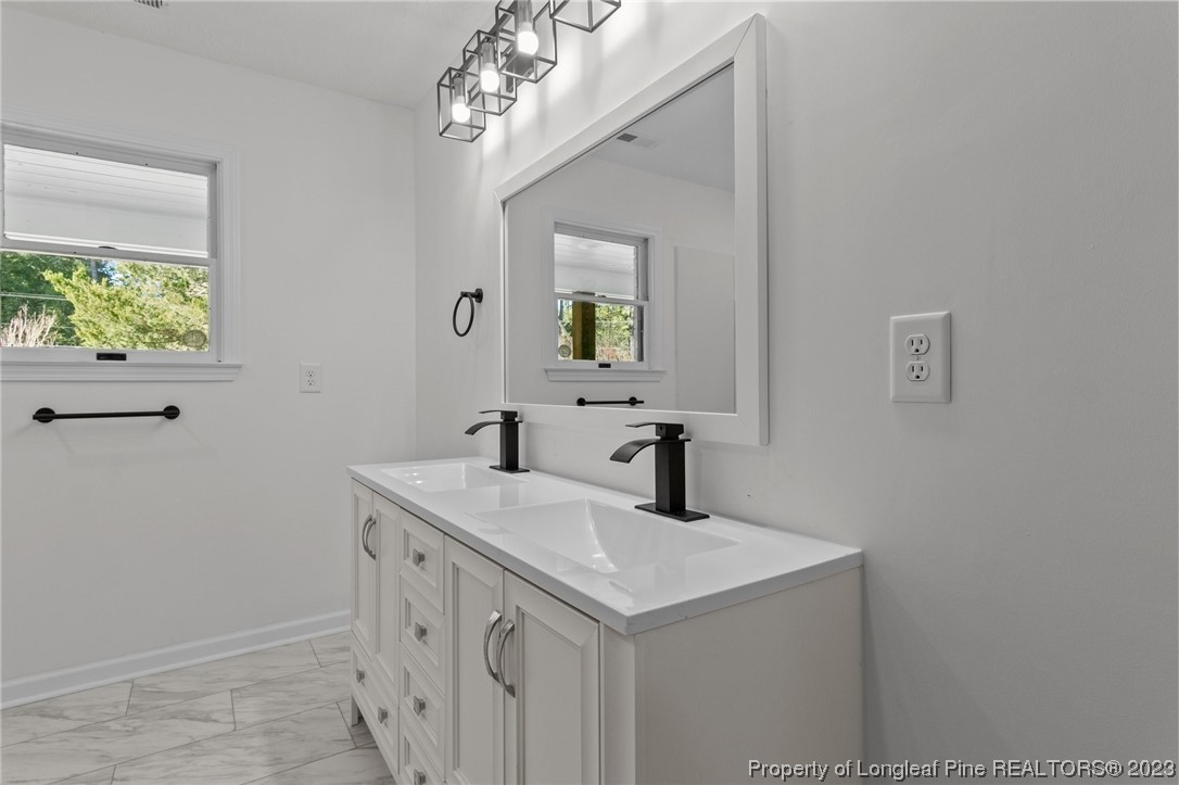 4659 Tabor Church Road Fayetteville, NC 28312 - Photo 23 of 50 a bathroom with a sink and a mirror