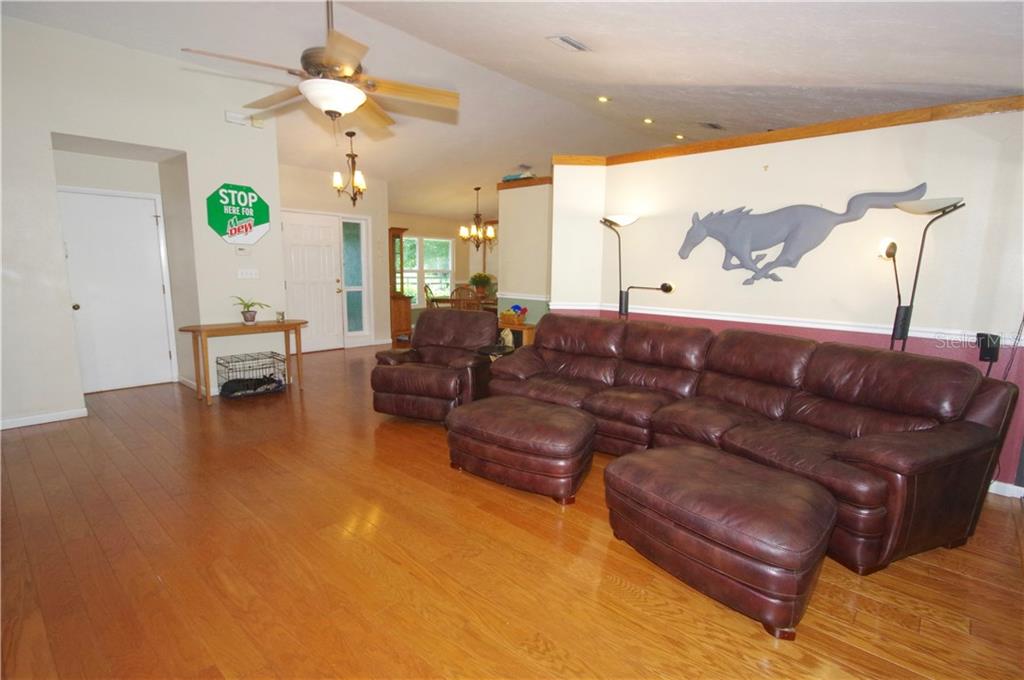 5349 Old Ranch Road Sarasota, FL 34241 - Photo 10 of 25 LIVING ROOM; DOOR TO THE LAUNDRY ROOM (LEFT); FRONT DOOR (CENTER); DINING ROOM (RIGHT)