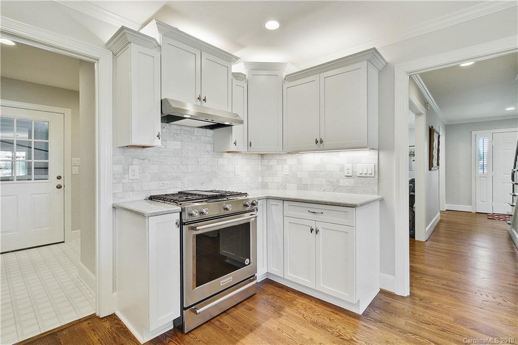 9049 Stacy Howie Road Indian Land, SC 29707 - Photo 15 of 36 a kitchen with granite countertop wooden floors and white stainless steel appliances
