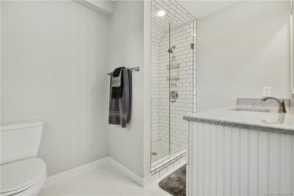 9049 Stacy Howie Road Indian Land, SC 29707 - Photo 22 of 36 a bathroom with a granite countertop sink a toilet and shower
