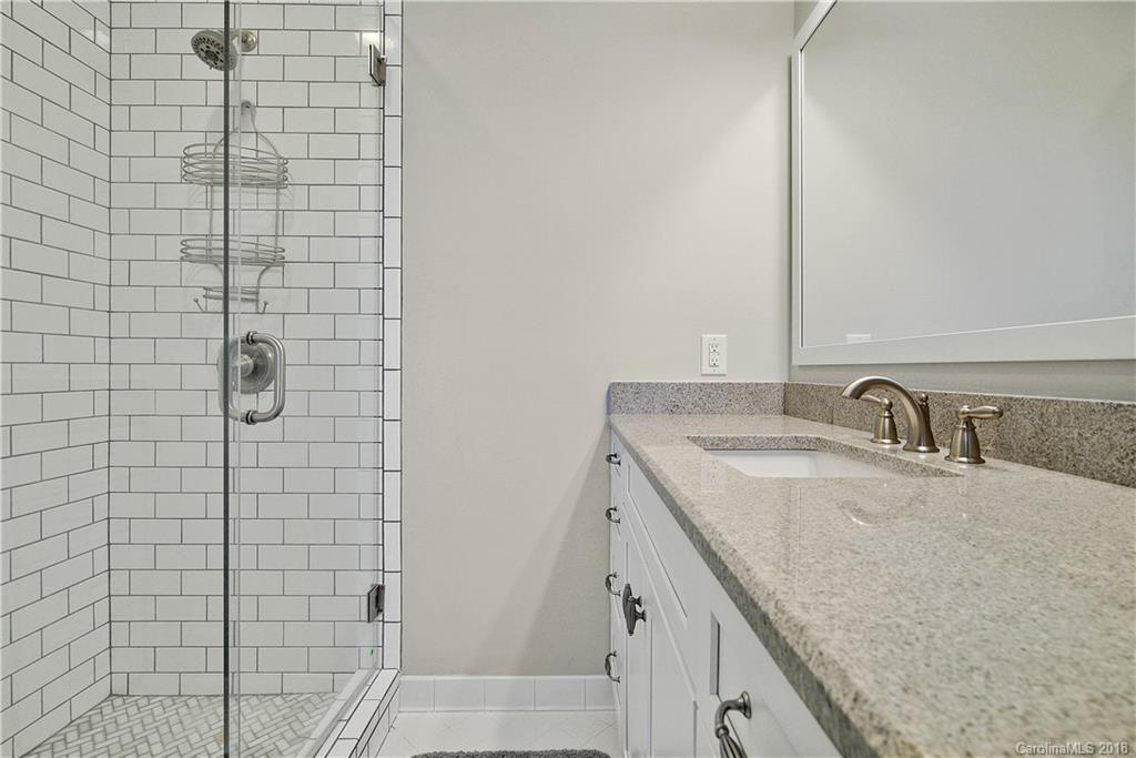 9049 Stacy Howie Road Indian Land, SC 29707 - Photo 23 of 36 a bathroom with a granite countertop sink and a mirror