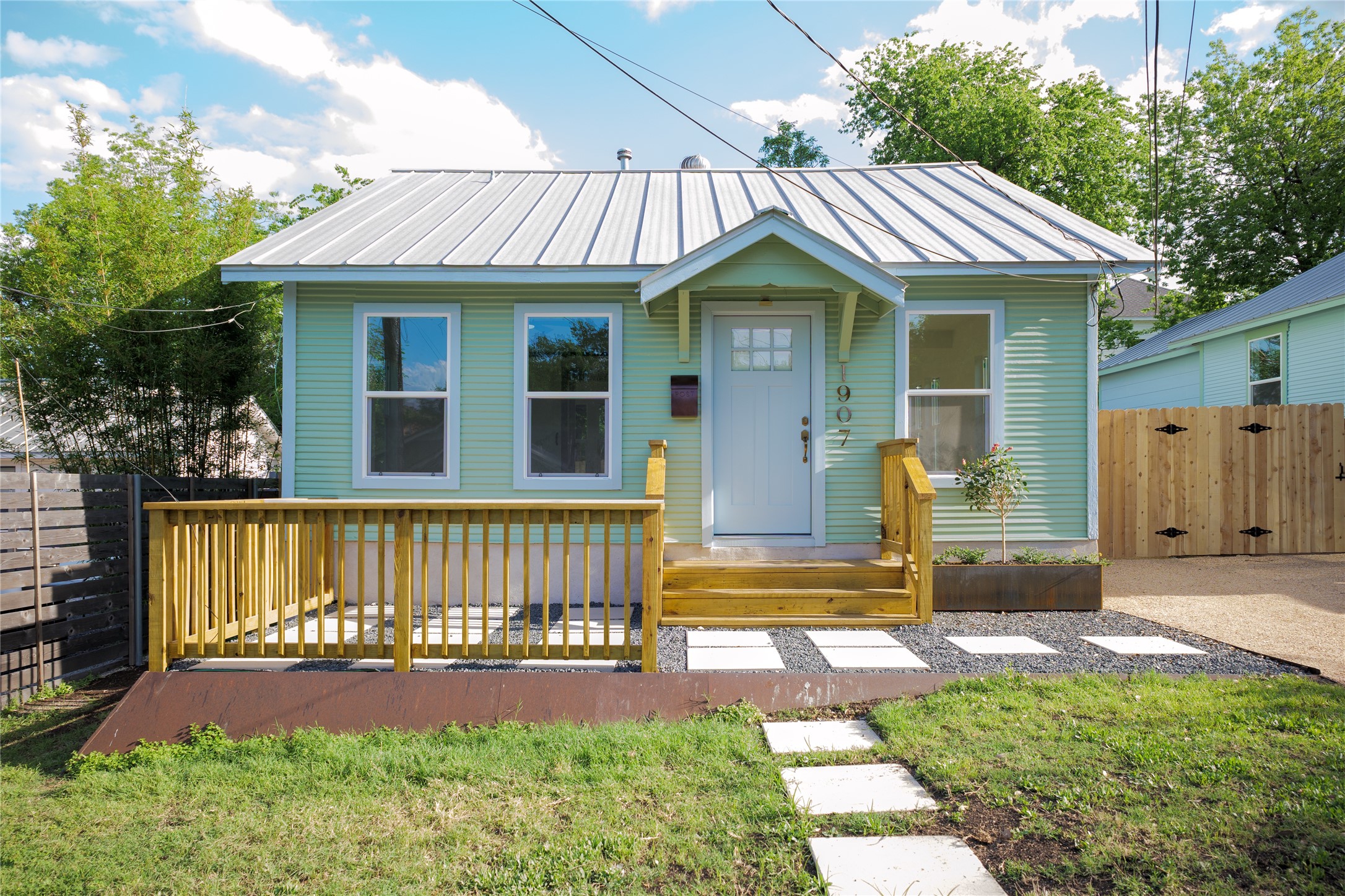 Bungalow-style home with a gate and a metal roof