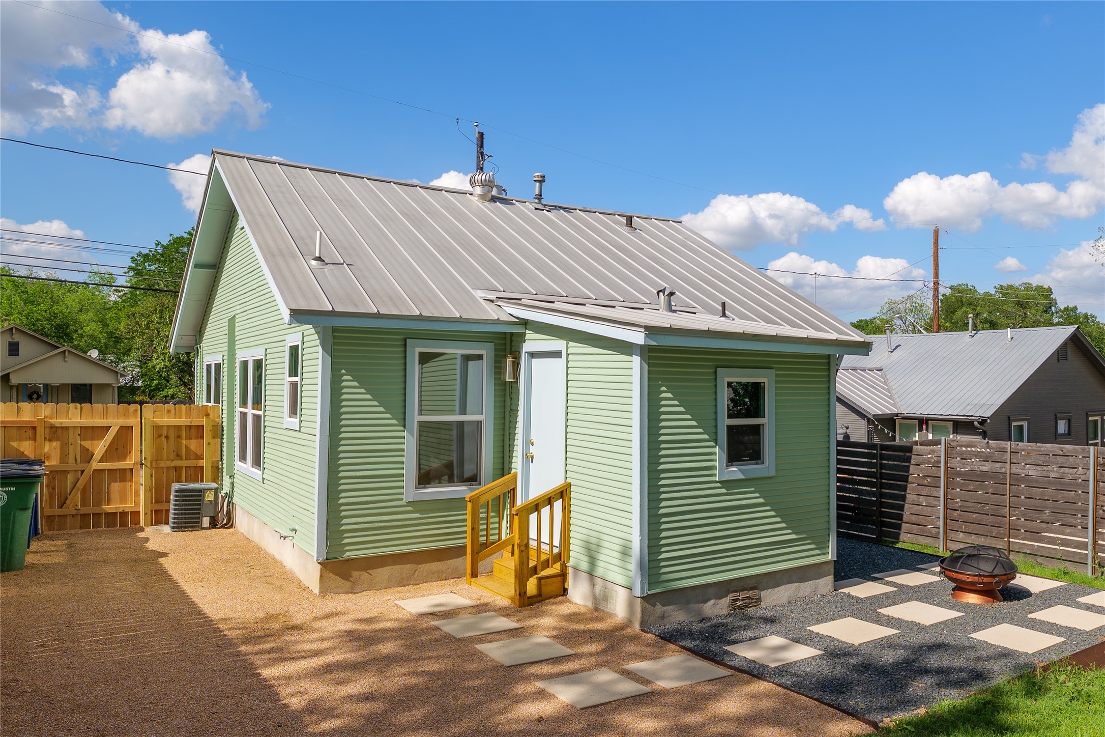 1907 East 21st Street Austin, TX 78722 - Photo 26 of 31 Rear view of property featuring a fire pit, a metal roof, a gate, a patio area, and entry steps