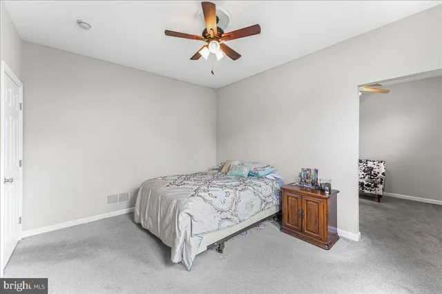 a bedroom with a bed and a ceiling fan