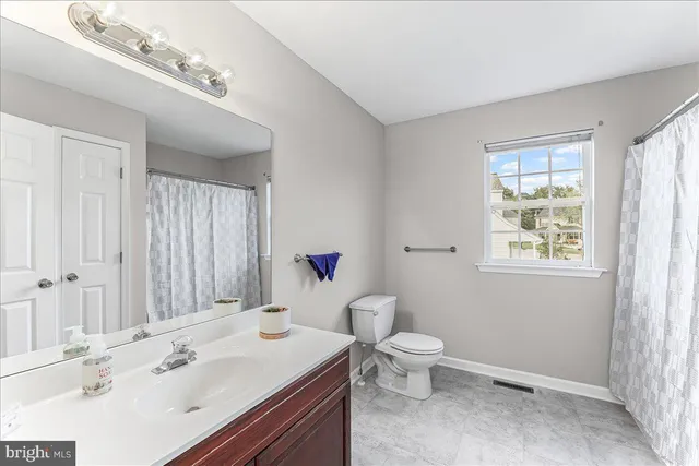 a bathroom with a sink a toilet and a large mirror