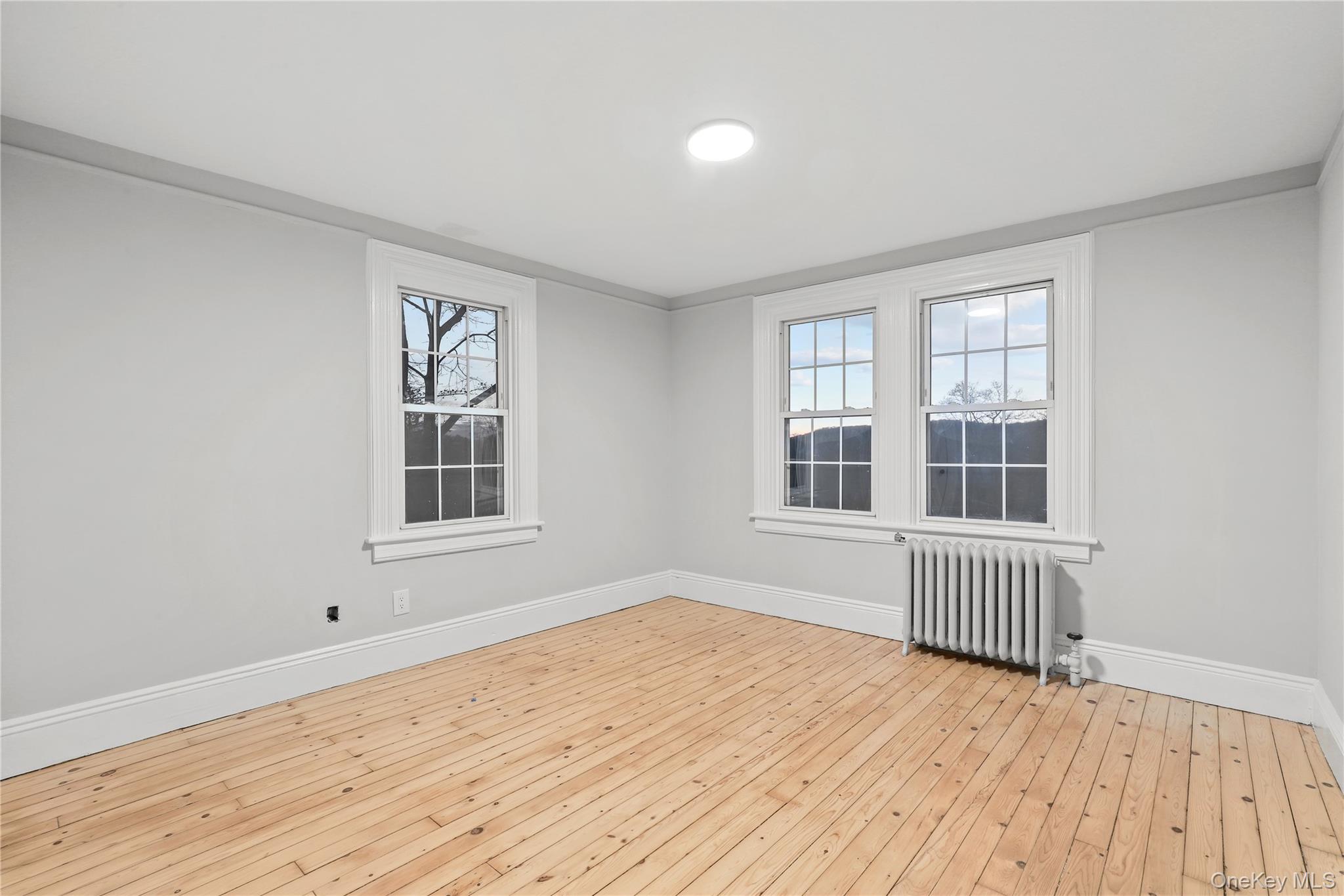 350 Commerce Street Hawthorne, NY 10532 - Photo 17 of 22 a view of an empty room with wooden floor and a window