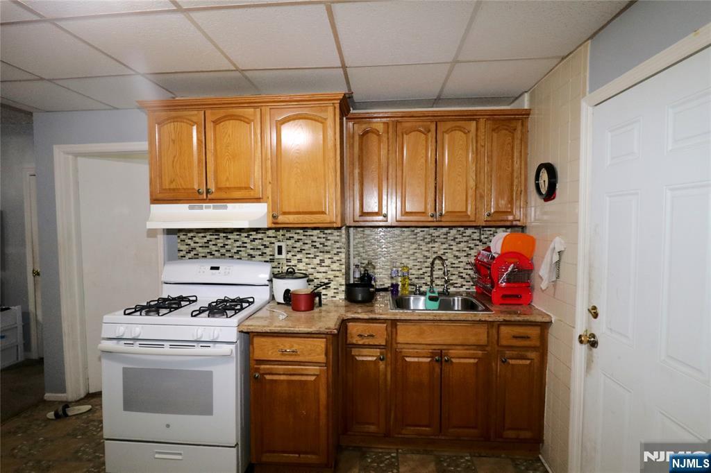 233-235 Adams Street Newark, NJ 07105 - Photo 8 of 20 a kitchen with stainless steel appliances a stove a refrigerator and cabinets