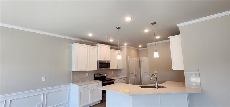 1476 Fern Ridge Lane Norcross, GA 30093 - Photo 17 of 19 a view of a kitchen with kitchen island a sink stainless steel appliances and cabinets