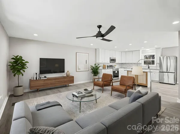 a living room with furniture kitchen view and a potted plant