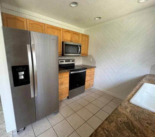 a kitchen with stainless steel appliances granite countertop a sink stove and cabinets