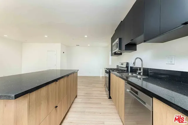 a kitchen with granite countertop a sink and cabinets