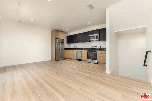 a view of kitchen with stainless steel appliances kitchen island a refrigerator sink and cabinets