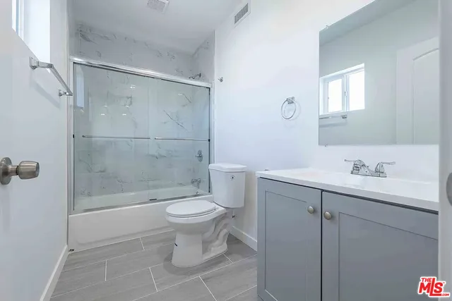 a bathroom with a toilet a sink a mirror and vanity